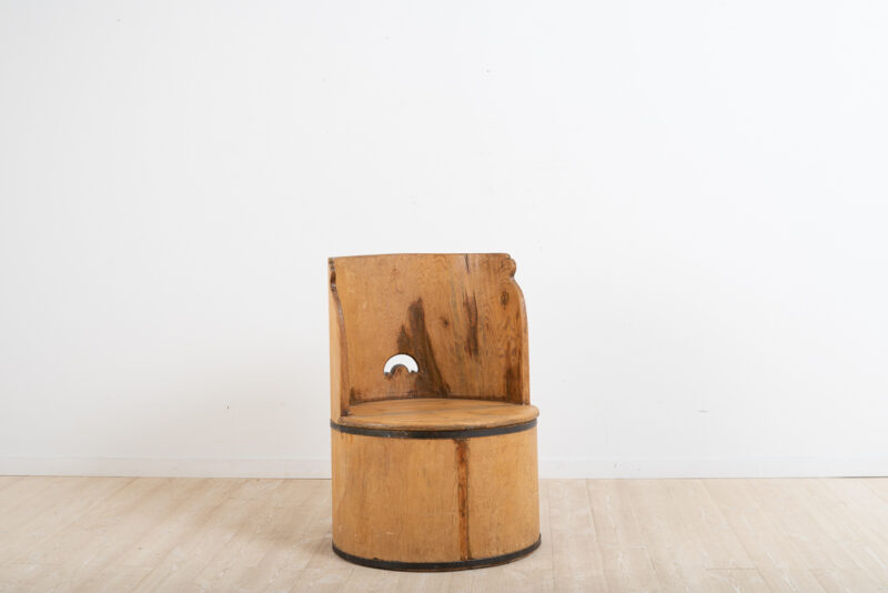 Swedish kubbstol manufactured from pine. A primitive chair manufactured from a hollowed tree trunk. From the late 19th century. Storage under the seat. Minor dry cracks.