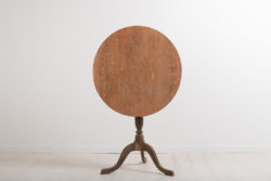 Gustavian pedestal table from the late 18th century. The table top is round and resting on a frame with a tripod foot. Wooden carved decorations along the foot.