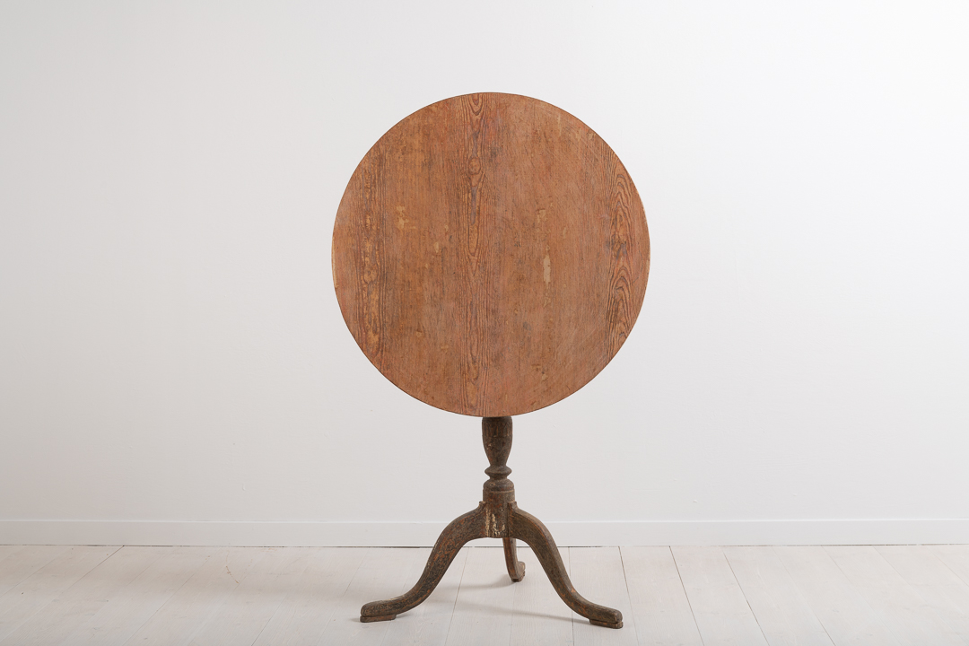 Gustavian pedestal table from the late 18th century. The table top is round and resting on a frame with a tripod foot. Wooden carved decorations along the foot.