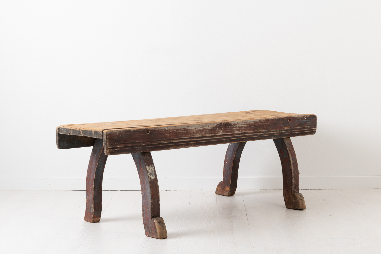 Late 18th century bench in folk art from northern Sweden. The bench is primitive and rustic with original distressed paint and authentic patina