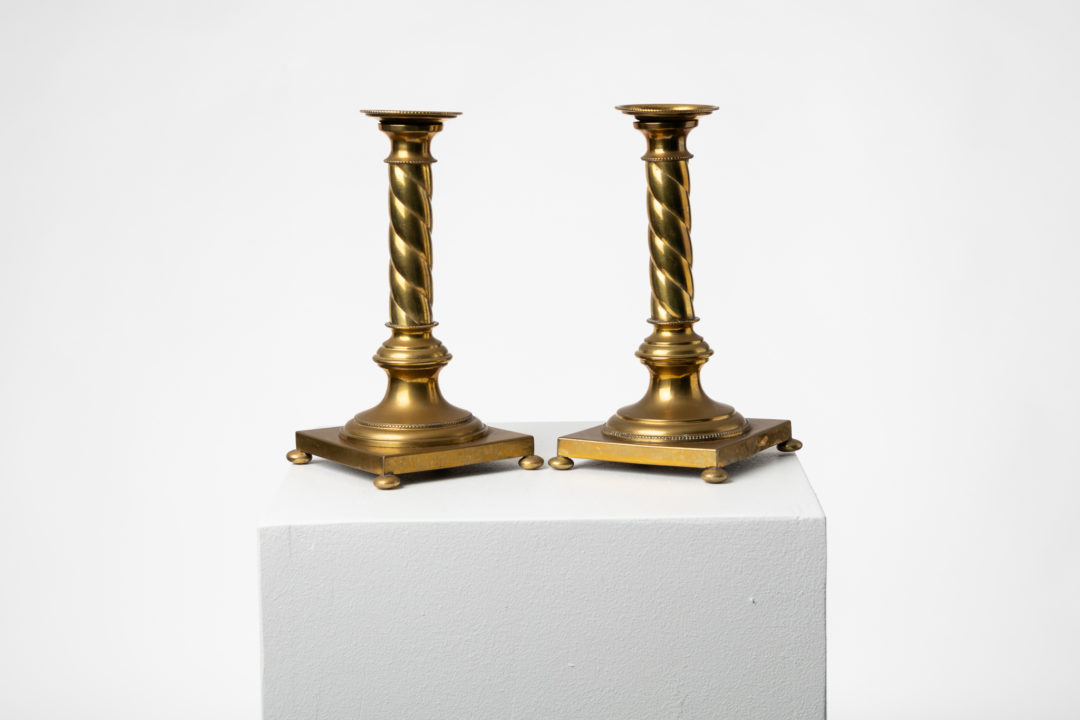 Swedish candle sticks in brass made during the later part of the 1800s. The pair are of the gustavian style with a square base, small round feet and a turned column
