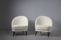 Scandinavian modern sheepskin chairs from the mid 20th century attributed to Arne Norell, Sweden. The chairs have an asymmetrical back