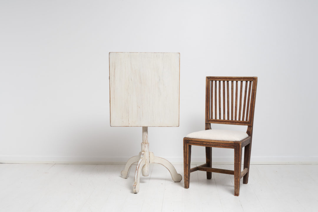 Tilt top column table made in pine from Northern Sweden. The table is charming in its simplicity with distressed white paint and rustic details.