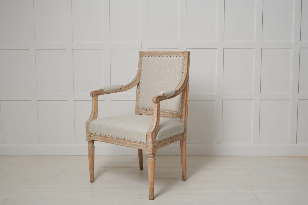 Swedish gustavian upholstered armchair from the late 18th century, circa 1790. The armchair has a straight shape with hand carved wooden decorations all over the chair. The decor spans around the backrest, down the armrest and around the seat itself, no space left forgotten. The chair has a regal and stately appearance with a touch of luxury, making it a statement piece to add to any space.
The armchair is steady with the original padding in the seat, back and armrests. Newly upholstered in a light toned and durable linen fabric that agrees well with the natural patina of the wood. Made in Swedish pine. Seating height is 45 cm.