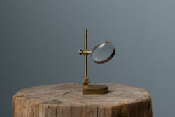 Antique brass magnifying glass from the second half on the 1800s. The magnifying glass is on a small stand and is ideal for tables or to keep on a decorative shelf.