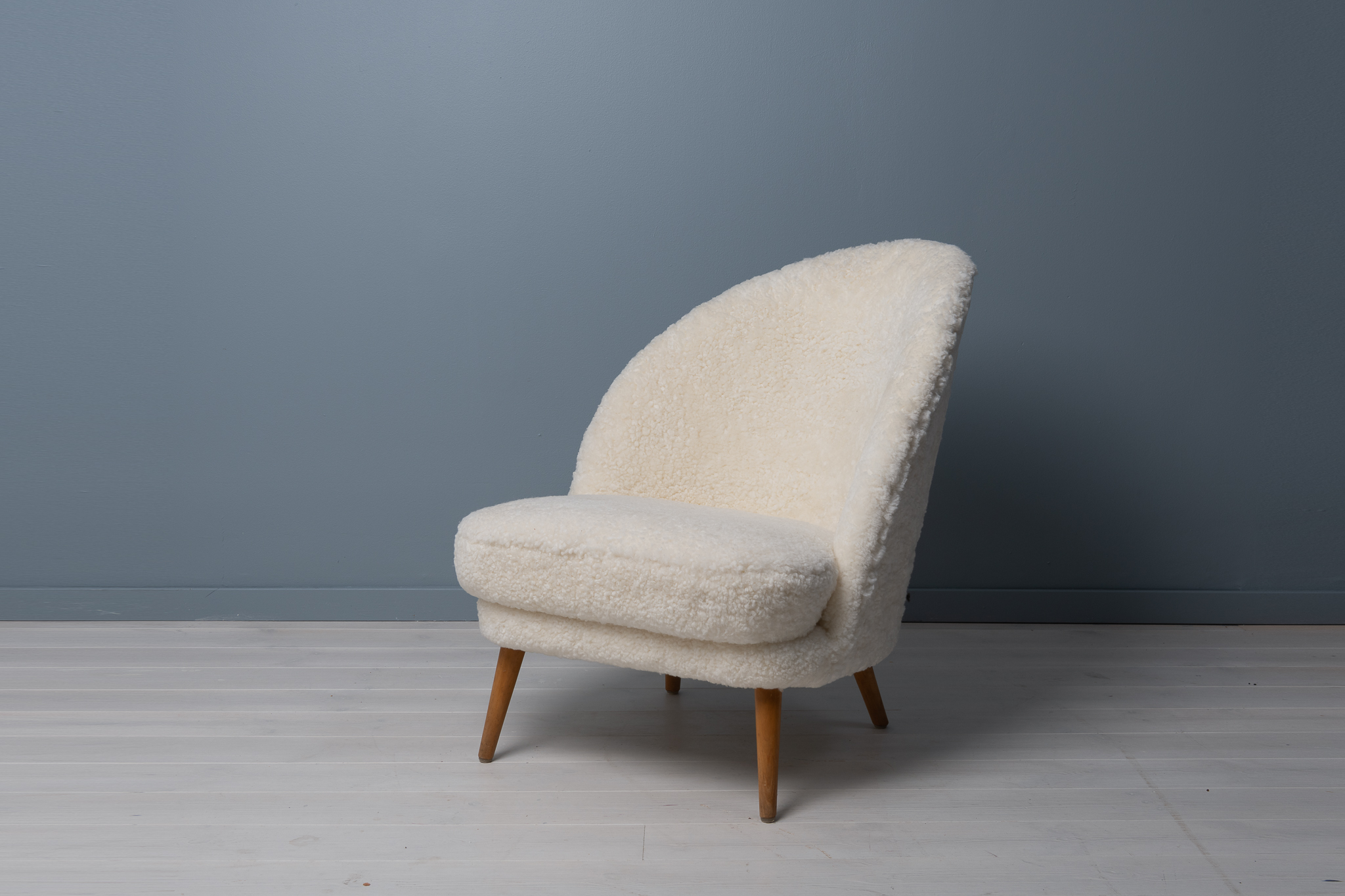 Scandinavian modern sheepskin chairs from the mid 20th century attributed to Arne Norell, Sweden. The chairs have an asymmetrical back