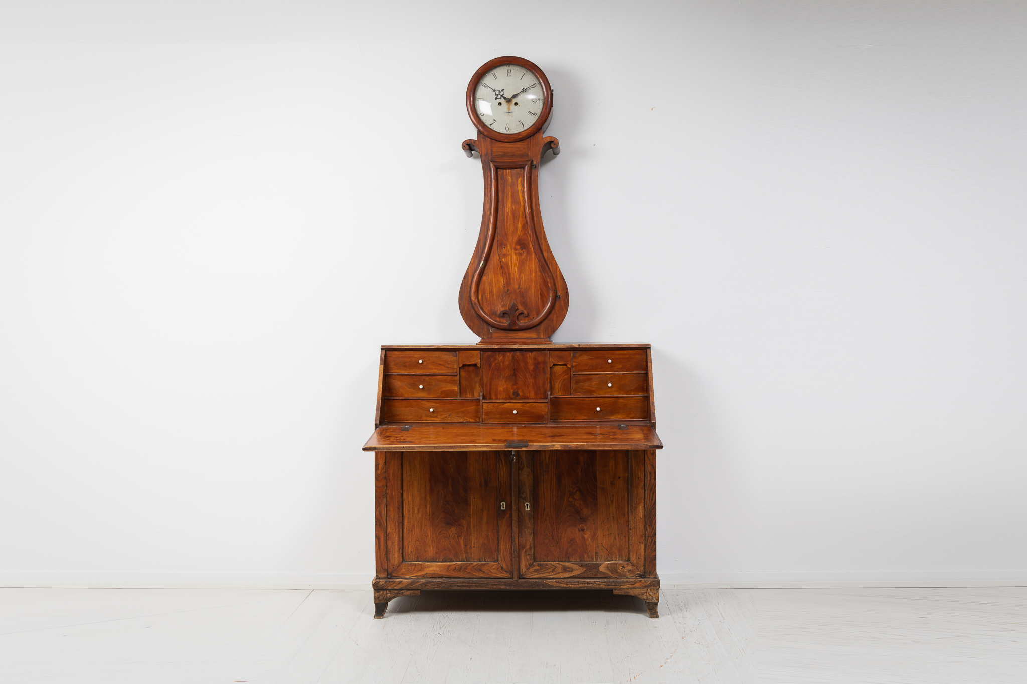 Swedish antique clock cabinet made during the early to mid 1800s, circa 1820 to 1840. The cabinet is veneered and waxed elm.