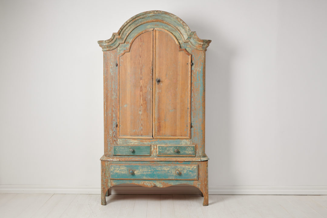 Antique rococo country cabinet made by hand in solid Swedish pine. The cabinet is an authentic antique country house furniture with traces of the original paint