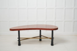 Swedish Grace coffee table from the 1930s to 1940s. The table has a kidney shaped table top that is veneered in walnut and black legs