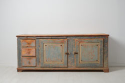 Low and wide genuine sideboard from the mid 1800s. The sideboard is a genuine Swedish country house furniture made in painted pine