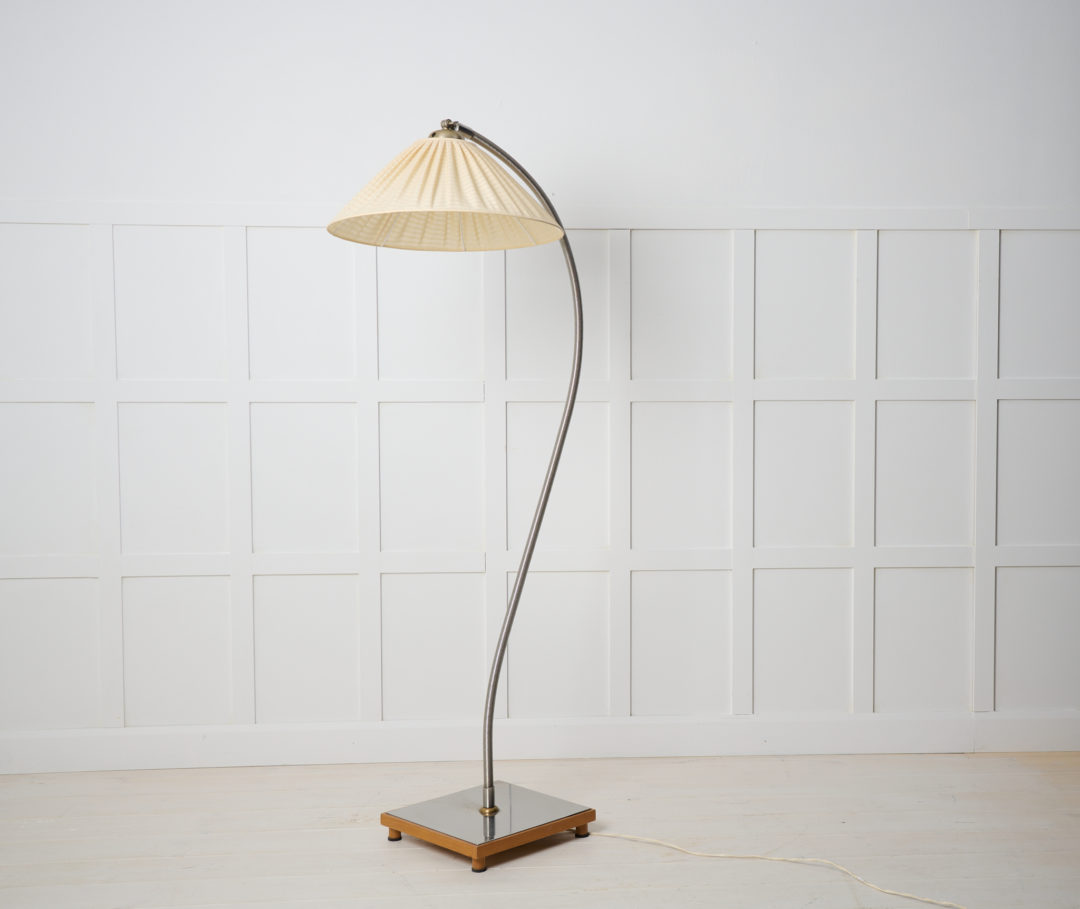 Swedish modern floor lamp in polished steel. The lamp is from around 1930 to 1940 and is made in Sweden. The lamp shade is original