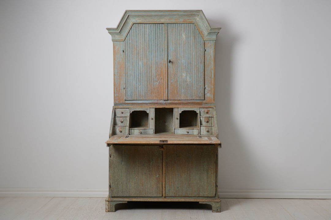 Genuine antique secretary cabinet from Sweden made in gustavian style. The piece is a secretary desk with an upper cabinet, made by hand in solid pine around 1820 in northern Sweden