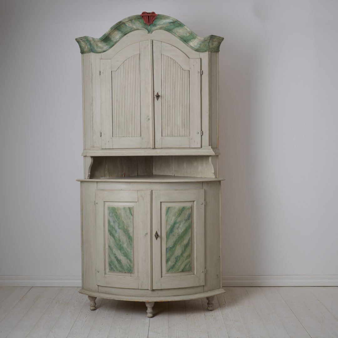 Antique Swedish corner cabinet made during the early 1800s. The cabinet is made in the transitional style where rococo became neoclassical
