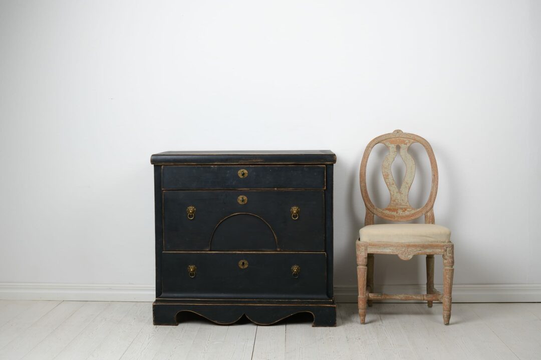 Antique Swedish chest of drawers in empire style from around 1840. The chest is made by hand in solid pine with three large, functional drawers.