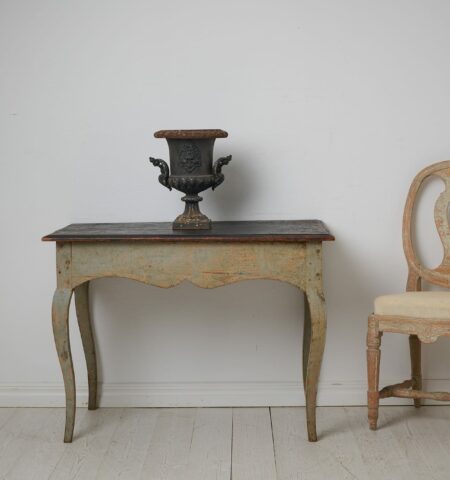 Swedish antique rococo table from the 1770s. The table has a rectangular table top with curved rococo legs and curved, bevelled aprons.