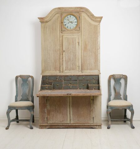 Rare Antique Secretary Cabinet in rococo with a clock. The cabinet is made by hand in solid pine around 1820 in northern Sweden. The cabinet is made in two parts