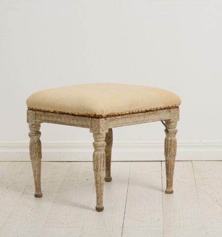 Genuine antique foot stool from the Swedish gustavian period around 1770 to 1780. This Swedish antique has classic carved wooden decor on the legs and sides.