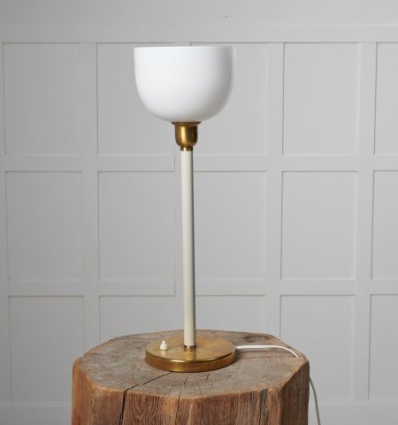 Swedish modern table light from the 1930s to 1940s. The light is likely by Böhlmarks SE. It has a foot in brass with a white stem.