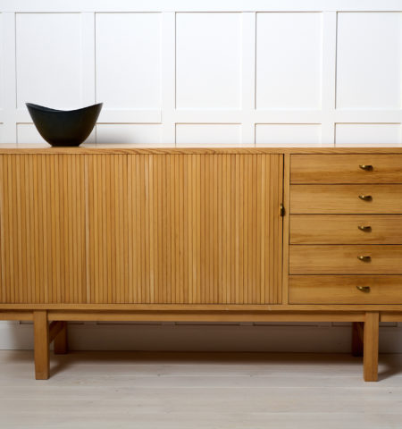 Swedish modern low sideboard from around 1960 to 1970. The sideboard is made in pine which is unusual to see. It has five drawers and a jalousie-door