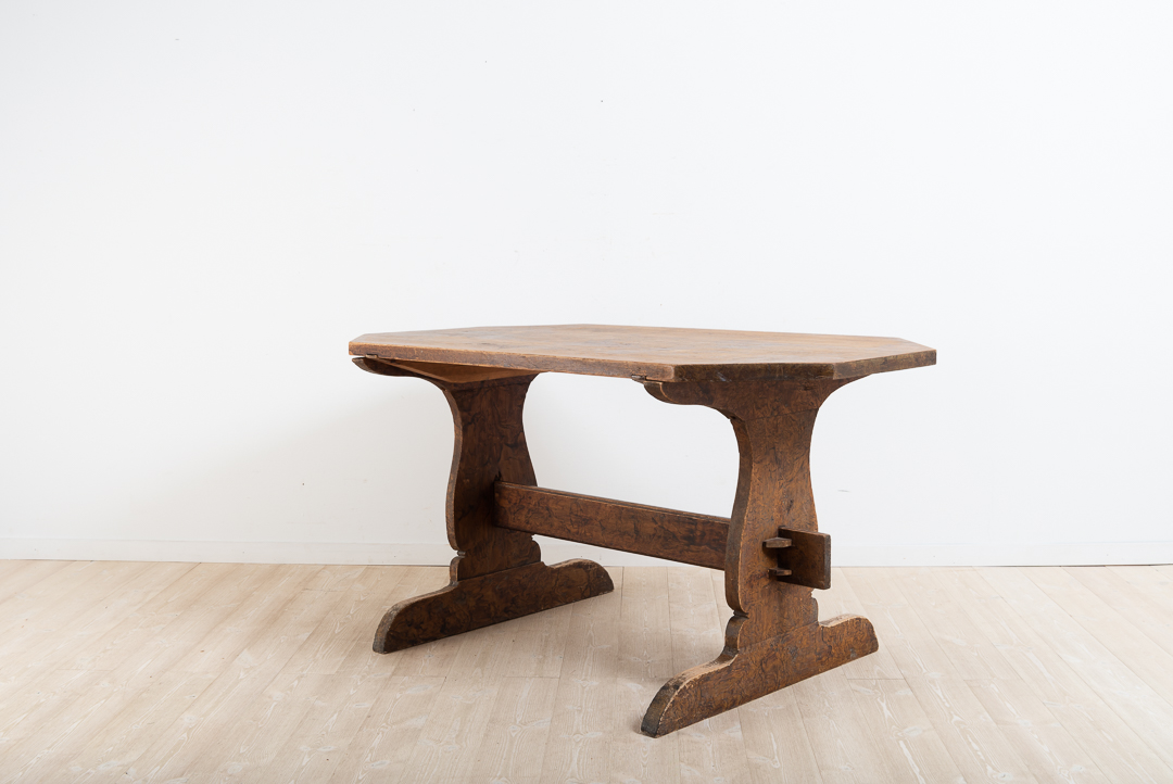 Folk art dining table from northern Sweden. Old fashioned model with a detached table top resting on the leg frame. Original imitation painting with some wear on the table top