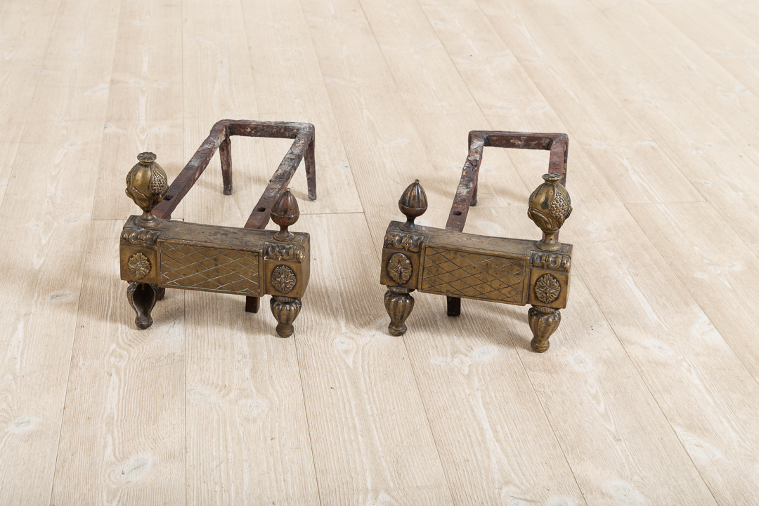 Pair of two andirons in iron. The frame is decorated with gustavian decorations in brass. Manufactured during the late 1700s.