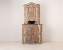Rococo corner cabinet from around 1770. Made in Northern Sweden the cabinet is in two parts with rustic patina and original blue paint