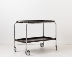 Art Deco bar cart from the 1930s. Frame made in nickel-plated metal with trays in dark stained wood. The tray have loose glass plates on top