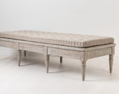Low gustavian bench from Sweden. The bench is from the turn of the century 1700 to 1800. Made in painted pine with rich carved decorations.