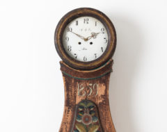 Classically curved mora clock from Dalarna in Sweden. The clock has original paint with extensive distress on the skirt. It has the year 1859 painted