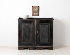 Black gustavian sideboard from Sweden made around 1790. The sideboard has two doors and a profiled bottom rim. Painted pine