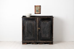 Black gustavian sideboard from Sweden made around 1790. The sideboard has two doors and a profiled bottom rim. Painted pine