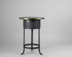 Swedish Art Deco table from the early 20th century, around 1920 to 1930. The table has a frame in metal with a patterned surface and a brass rim around the table top