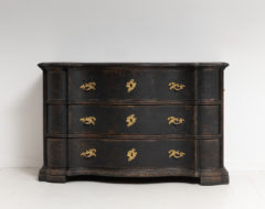 Late baroque chest of drawers with a curved front and black paint. The chest is subtle but impactful with the dark paint and lighter hardware