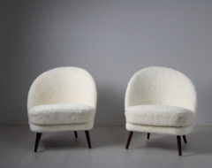 Scandinavian modern sheepskin chairs from the mid 20th century attributed to Arne Norell, Sweden. The chairs have an asymmetrical back
