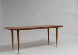 Scandinavian modern teak table from the 1960s. The coffee table has round slider legs with brass finishes. Good vintage condition consistent with age and use