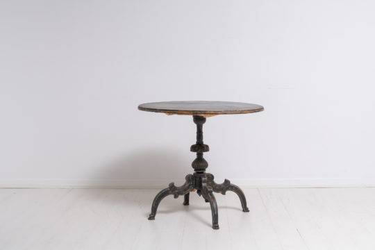Painted tilt top table from Sweden with distressed black paint and patina. Made during the mid 1800s, around 1860, the table has unmistakably antique