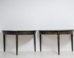 Black demi lune tables from northern Sweden made during the mid 19th century. The tables are from around 1860 and has black distressed paint