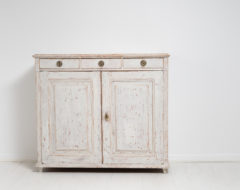 White gustavian sideboard in pine from Sweden. The sideboard is solid pine with distressed white or light grey paint. Hardware in brass.