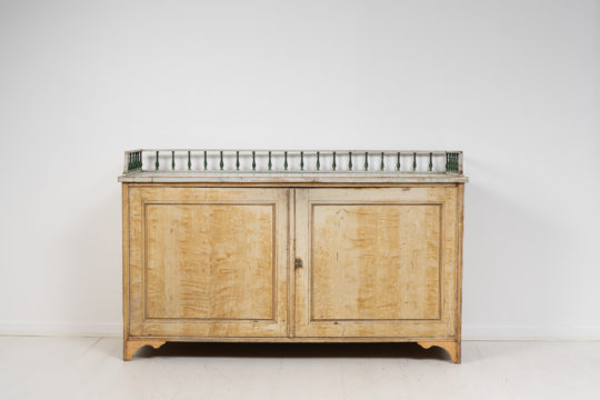 Wide and low gustavian sideboard from Sweden. The sideboard is a gustavian country house furniture made around the year 1800.