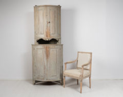 Tall gustavian corner cabinet in two parts. The cabinet has a rounded front with original paint from the time it was made