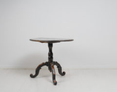 Small black tilt-top table from Sweden made during the mid 19th century, around 1860. The table is painted with black paint that has become distressed