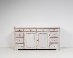 Low and wide Swedish sideboard from the mid 1800s, around 1860. The sideboard has 10 drawers framing the two doors in the centre.