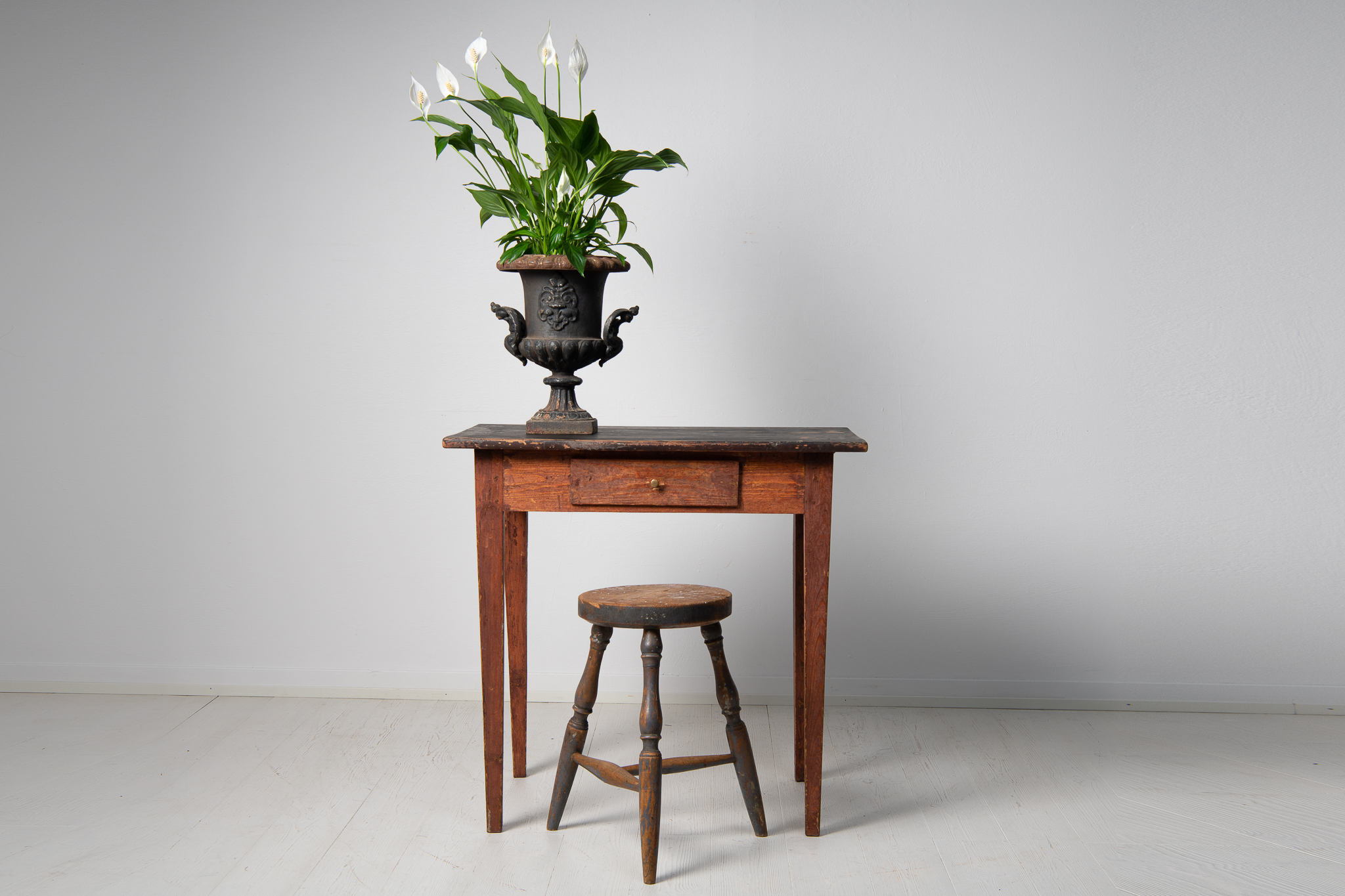 Swedish folk art side table in gustavian style with tapered legs and a drawer. The table is painted pine with traces of the original paint