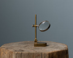 Antique brass magnifying glass from the second half on the 1800s. The magnifying glass is on a small stand and is ideal for tables or to keep on a decorative shelf.