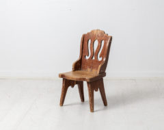 Unusual antique children's chair in folk art from Northern Sweden. The chair is from the mid 1800s and made in pine. It has paint from the late 1800s