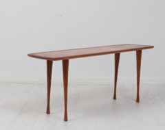 Scandinavian modern teak table from the mid 20th century, around 1960. The table is danish and has a thin and narrow shape.