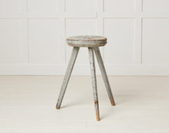 Antique Swedish rustic stool in folk art made with three legs. The stool has a round seat and is in its untouched original condition.