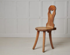Swedish folk art chair made during the late 1800s. The chair is hand-made from pine with a heart cut out from the backrest.