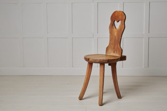 Swedish folk art chair made during the late 1800s. The chair is hand-made from pine with a heart cut out from the backrest.