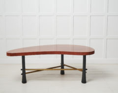 Swedish Grace coffee table from the 1930s to 1940s. The table has a kidney shaped table top that is veneered in walnut and black legs